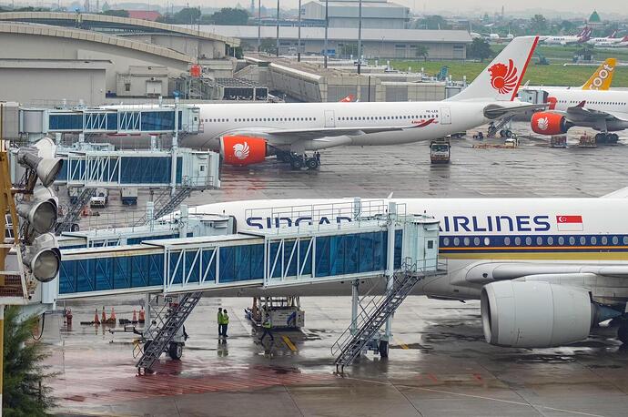 landscape-of-terminal-2-of-juanda-international-airport-which-is-equipped-with-a-modern-boarding-bridge-with-several-planes-parked-on-the-apron-indonesia-6-january-2024-free-photo
